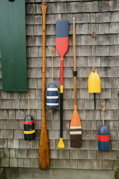 Oars and buoys on shingle wall in Maine 