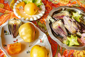 Fresh fruits and vegetables displayed on a patterned tablecloth