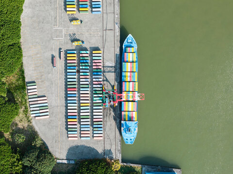 Model ship docked at vibrant cargo terminal with containers