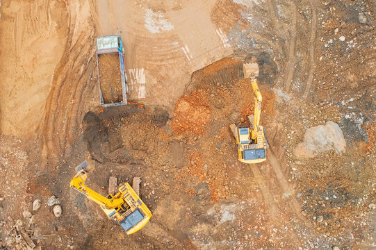 Construction Site with Excavators and Trucks Loading Gravel