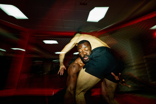 Black man fighter lifting partner
