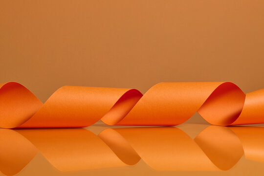 Vibrant Orange Ribbon Twisting Against Matching Background