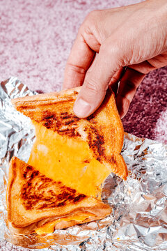 man taking a piece of a grilled cheese sandwich