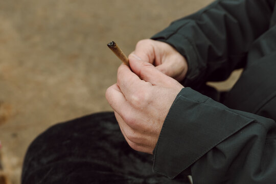 Person Holding a Cannabis Joint for Relaxation or Medical Use