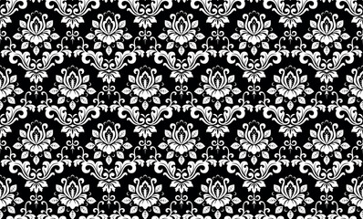 Wallpaper in the style of Baroque. White and black floral ornament. Seamless vector background. Graphic pattern for fabric, wallpaper, packaging. Ornate Damask flower illustration.