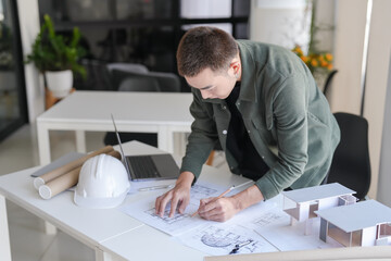 Asian man architect or interior designer holding compass drawing on blueprint&nbsp;