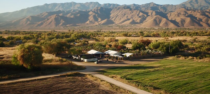 A high-altitude drone shot of a mountain range at sunrise, the first light casting long shadows over the peaks