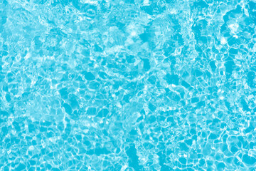 Obraz premium Blue water with ripples on the surface. Defocus blurred transparent blue colored clear calm water surface texture with splashes and bubbles. Water waves with shining pattern texture background.