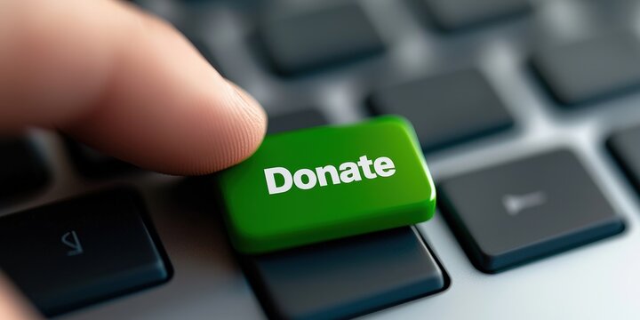 A close-up of a finger pressing a green "Donate" key on a keyboard, symbolizing online charitable contributions and digital philanthropy, Corporate Social Responsibility, CSR.