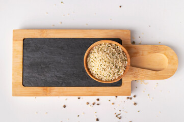 Hemp seeds in wooden bowls, kitchen writing board on light background, top view. Superfood, healthy...