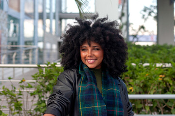 A Confident Woman is Enjoying the Urban Outdoors, Radiating Style with Her Beautiful Curly Hair