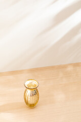 Copy space warm lighting background.Blank wallpaper with minimalist vase.Light and Shadow. Space for text.Backdrop.Studio photography.Sunshine. Chic style. Vase isolated on wooden. Home decor. Clean.