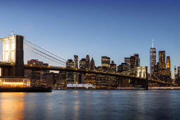 Fototapeta premium A panoramic sunset view of the Brooklyn Bridge stretching towards Manhattan