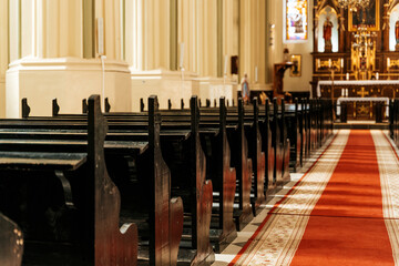Wooden church pews in a Catholic Christian church for believers.