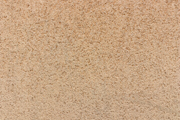 Texture of beige wall covered with limestone plaster, natural sand and stone cover material, background for wallpapers or web-banner design