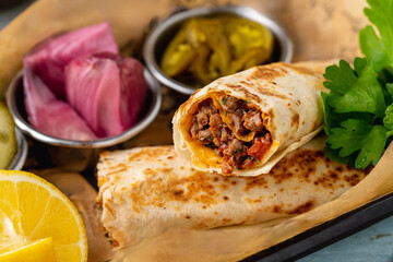 Turkish kebab tantuni served with sauce and pickles. Mersin tantuni wrap