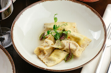ravioli with sauce and herbs on a white plate