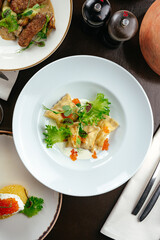 ravioli with sauce, herbs and caviar in a restaurant
