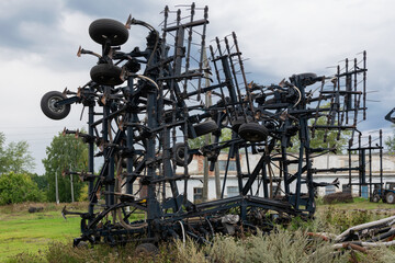Broken agricultural machinery and Old rustic farm equipment, abandoned in the countryside on a farm