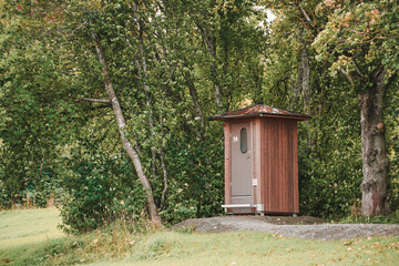 Wooden toilet in a green wooded area