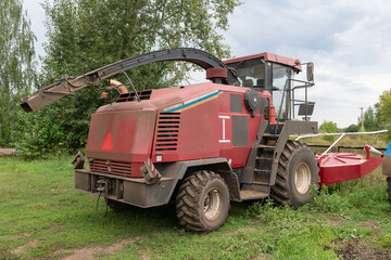 Fototapeta premium A broken agricultural harvester in a rural area on a farm awaiting repair