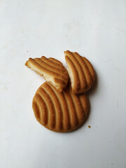 Round Whole Brown Color Biscuit and Cut Cookie isolated on white Background. Curve Shape pattern above the biscuit.