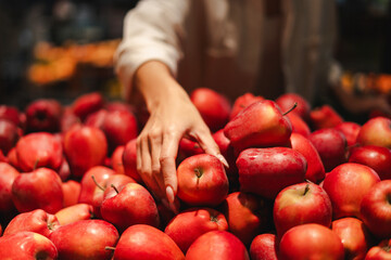 Woman choosing fresh red apples at the supermarket