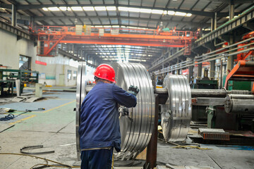 Workers on the production line of the strip steel coil factory are working