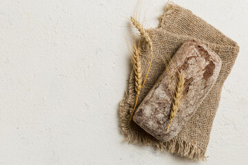 Fresh rye bread on napkin on rustic background, fresh bread top view