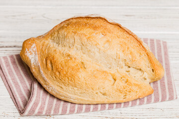 freshly baked bread with napkin on rustic table top view. Healthy white bread loaf isolated
