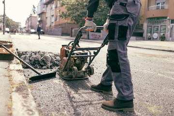 Obraz premium Construction worker working on a public city road reconstruction