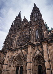 St. Vitus Cathedral at Prague Castle with dramatic gothic spires and detailed rose window under a...