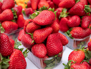 Fresh ripe strawberries stacked in plastic market trays, vibrant and juicy, perfect for healthy eating, summer produce, or farm-to-table concepts.