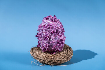 Creative Easter egg shape made of lilac spring petals flowers. Minimal holiday concept still life....
