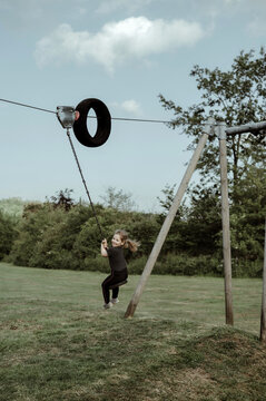 Girl is playing at cableway at playground. ridding at ropeway.