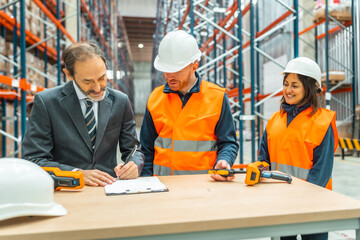 Manager signing delivery notes in logistics warehouse with workers