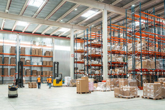 Warehouse workers managing logistics with forklifts and packages