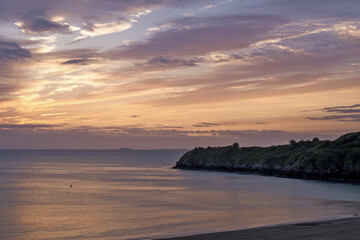 View of the sandy beach at low tide and sunset of Saint-Cast-Le-Guildo in summer in Côtes d'Armor, Brittany, France