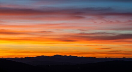 Fototapeta premium Vibrant sunset over distant mountains warm color palette. AI Generated