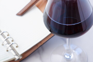 赤ワインを飲みながら、リング式のシステム手帳に日記をつけているイ