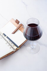 赤ワインを飲みながら、リング式のシステム手帳に日記をつけているイ