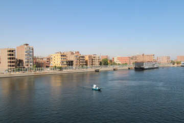Fototapeta premium View of Esna city with vendors in their rowing boat near the Esna Lock on the River Nile, Egypt