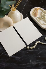 Blank cards mockup and home table decor top view flat lay with copy space on black marble table.Feminine, birthday, mother's day concept.