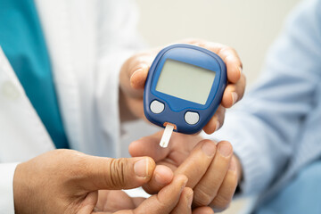 Doctor check diabetes from finger blood sugar level with finger lancet.