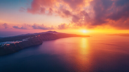 Aerial view of coastline with dramatic sunset sky reflecting on ocean water surface at dusk or dawn