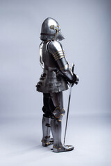 Full Suit of Fourteenth Century Knight's Plate Armor. Impressive display of medieval protective gear, including helmet, breastplate, gauntlets, and greaves