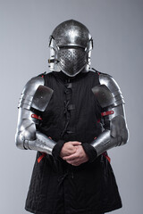 Knight in Full Plate Armor. This image shows a person fully clad in shiny silver plate armor