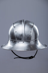 Silver Helmet with Wide Brim and Rivets. This image shows a shiny silver helmet featuring a wide,...