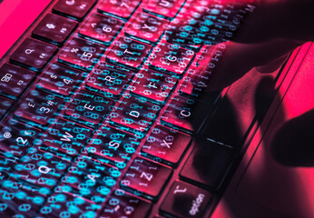 Hands typing on a laptop keyboard with digital overlay representing cybersecurity and cyber crime