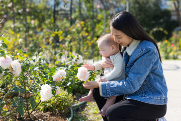 Mother holding baby in flower garden park
